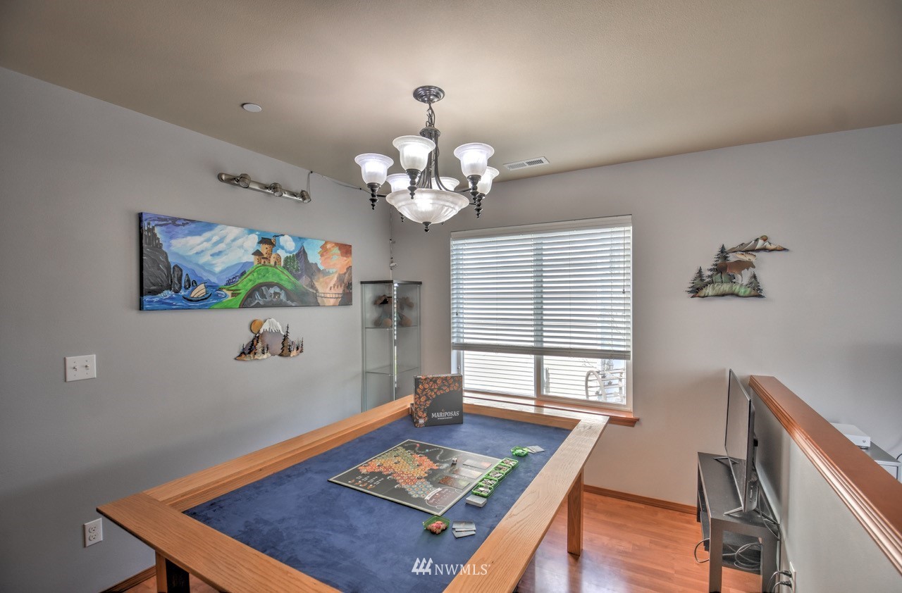 1303 Foreman Road DuPont, WA 98327 - Photo 5 of 31 a view of a dining room with furniture a chandelier and wooden floor