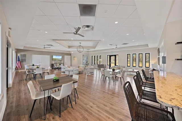 a living room with furniture large windows and wooden floor