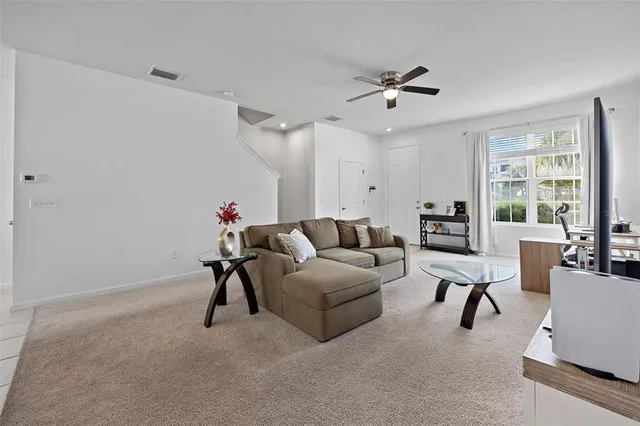 a kitchen with stainless steel appliances kitchen island granite countertop a refrigerator a stove a sink a dining table and chairs