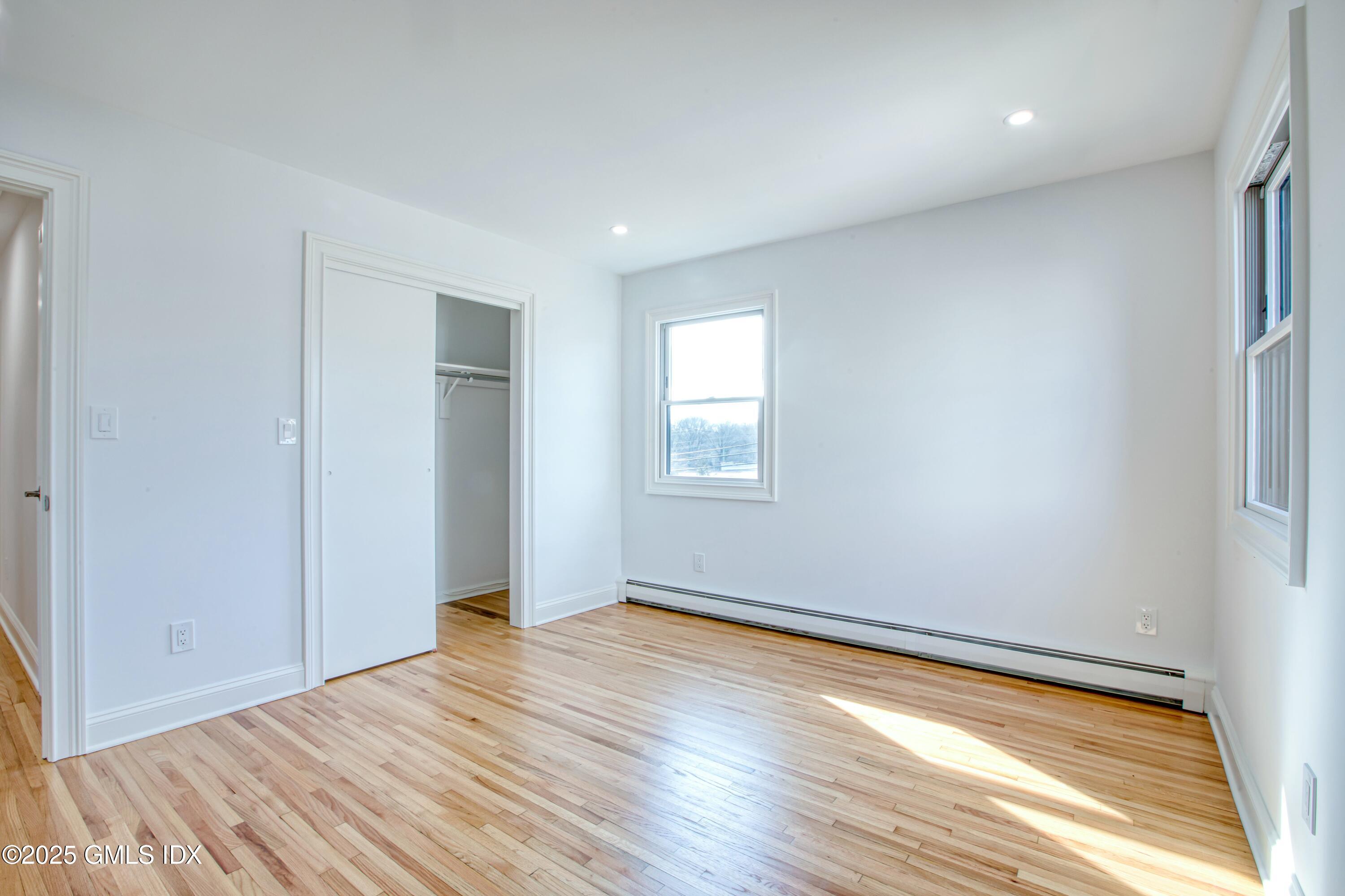 9 Apache Place Riverside, CT 06878 - Photo 19 of 23 an empty room with wooden floor and windows