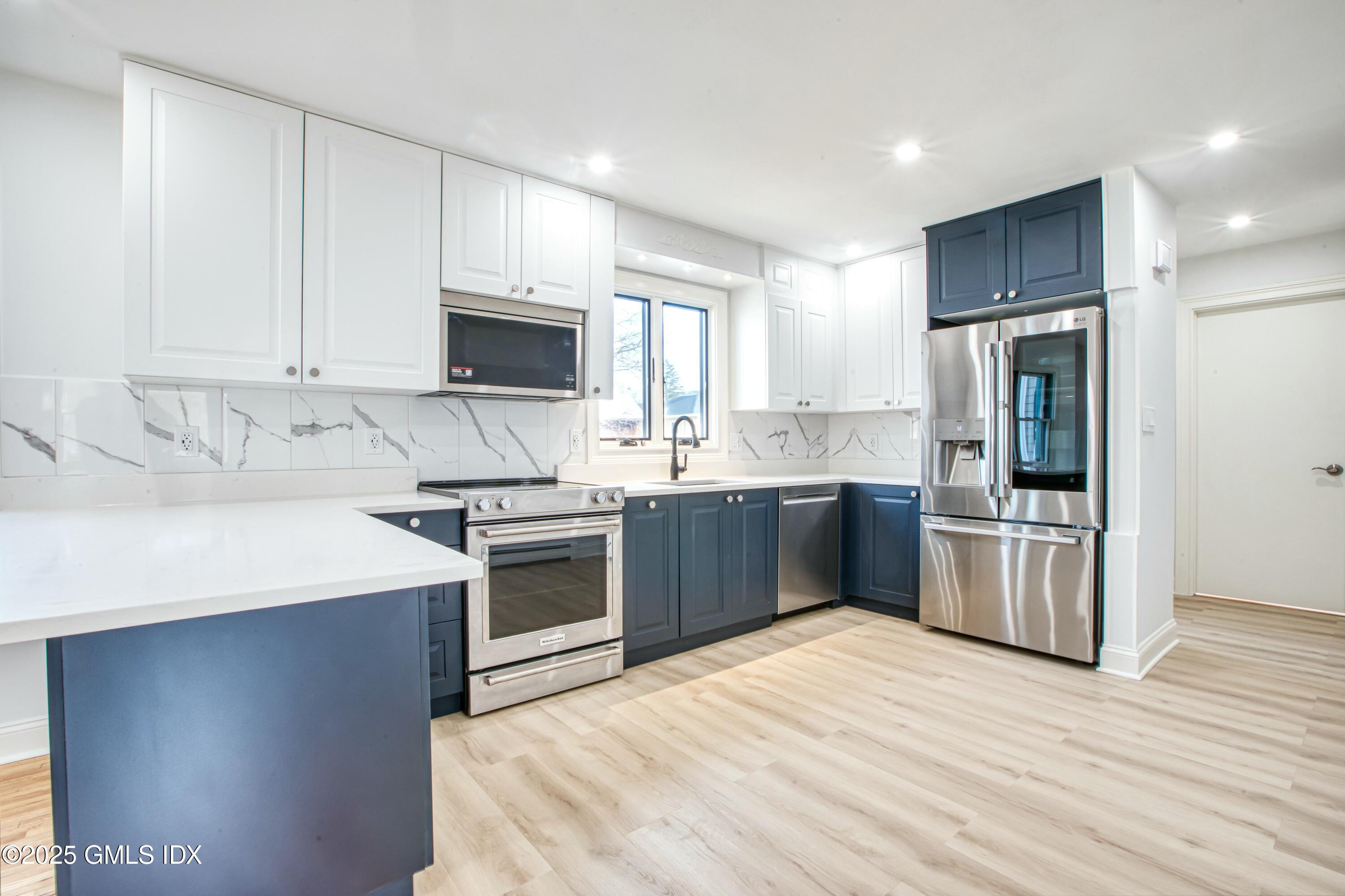 9 Apache Place Riverside, CT 06878 - Photo 7 of 23 a kitchen with stainless steel appliances granite countertop a stove a sink dishwasher a refrigerator and a oven with wooden floor