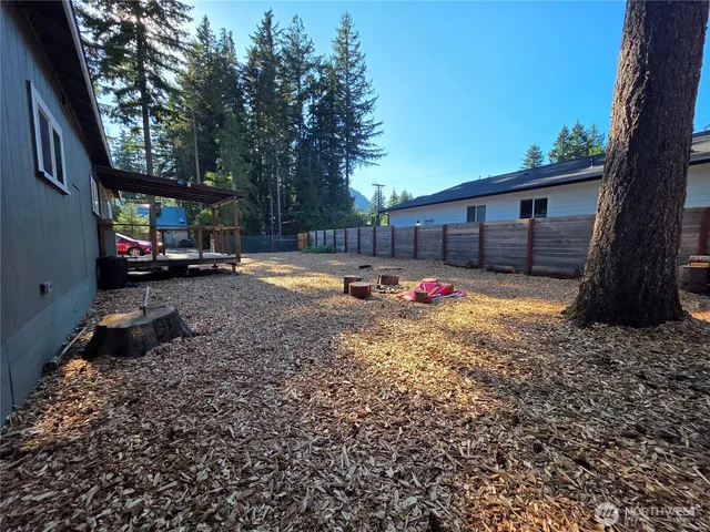 a backyard of a house with barbeque oven table and chairs
