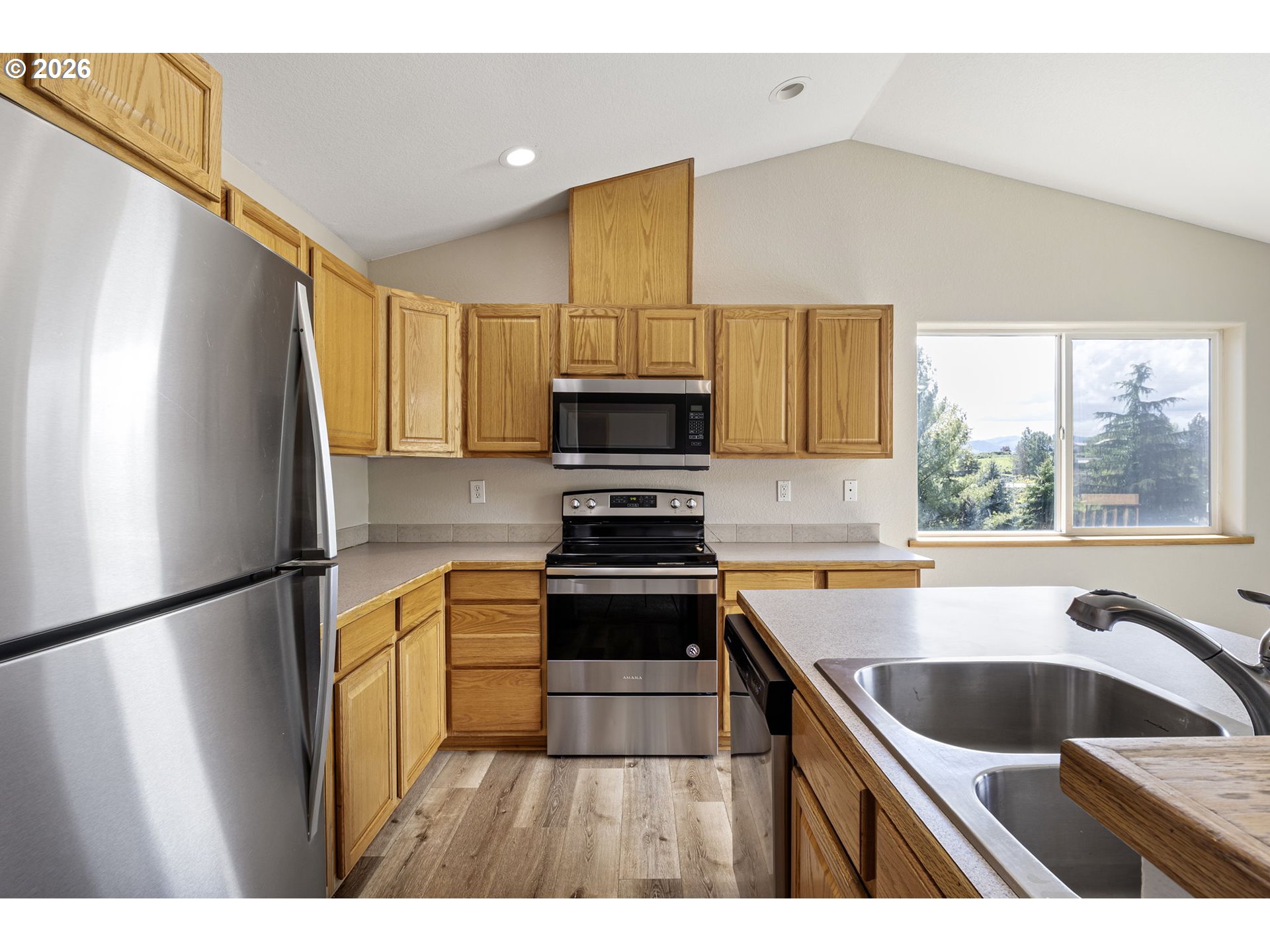 223 Armande Loop Roseburg, OR 97471 - Photo 10 of 35 a kitchen with a sink a stove a microwave and refrigerator