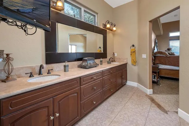 a spacious bathroom with a granite countertop double vanity sink and a mirror