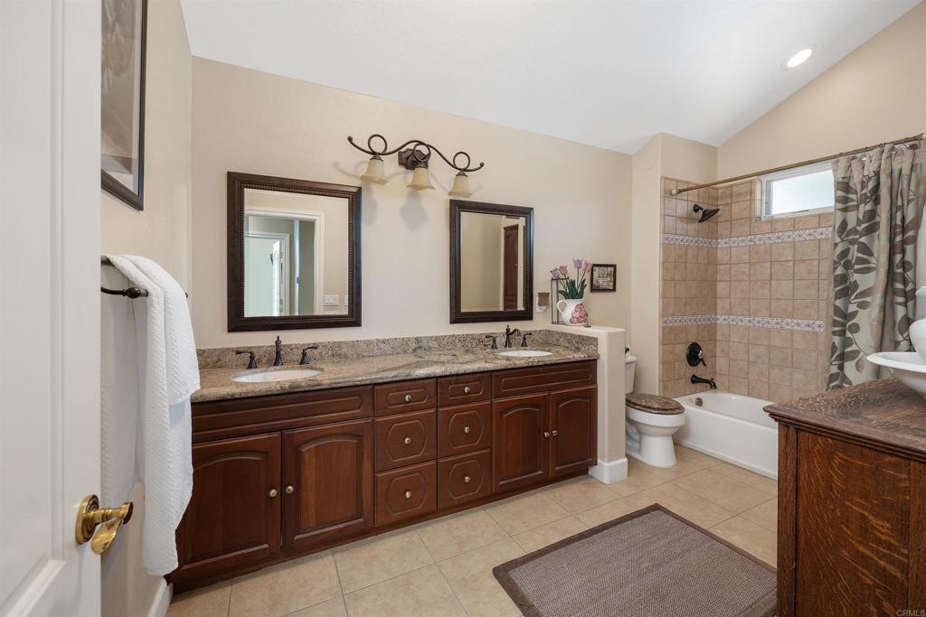 2016 South Grade Road Alpine, CA 91901 - Photo 16 of 27 a bathroom with a granite countertop double vanity sink a mirror and a toilet