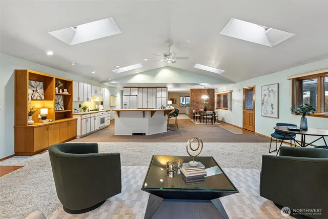 a living room with furniture kitchen view and a large window