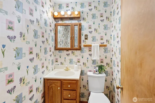 a bathroom with a sink a toilet and a mirror
