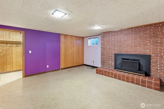 an empty room with windows and fireplace