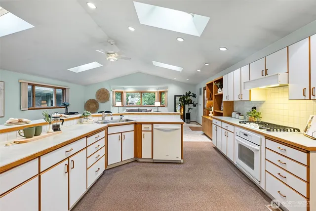 a large kitchen with stainless steel appliances lots of counter space and a sink