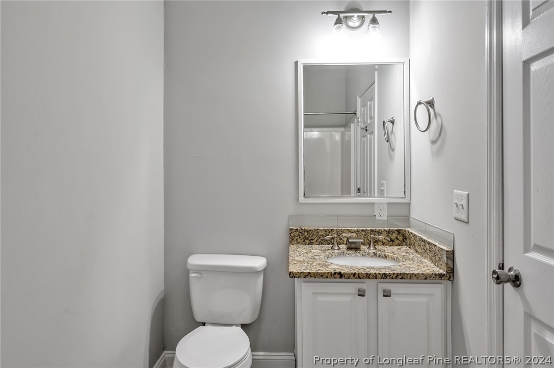 3713 Glenn Road Parkton, NC 28371 - Photo 15 of 17 a bathroom with a granite countertop toilet and a sink