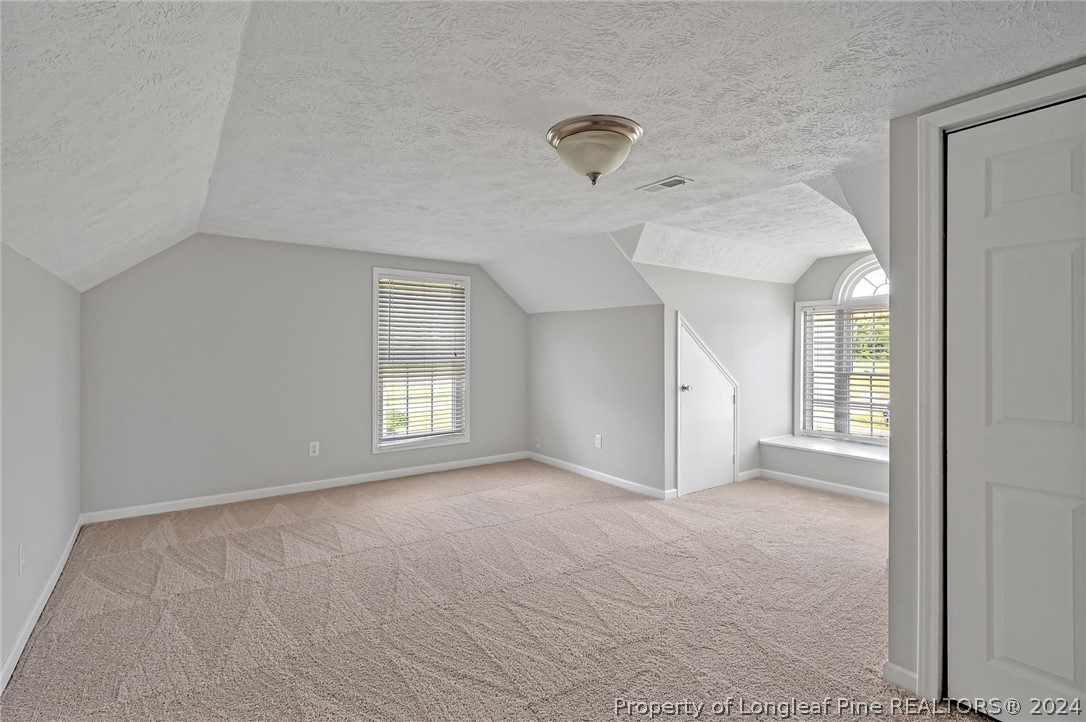 3713 Glenn Road Parkton, NC 28371 - Photo 3 of 17 a view of a big room with windows and chandelier fan