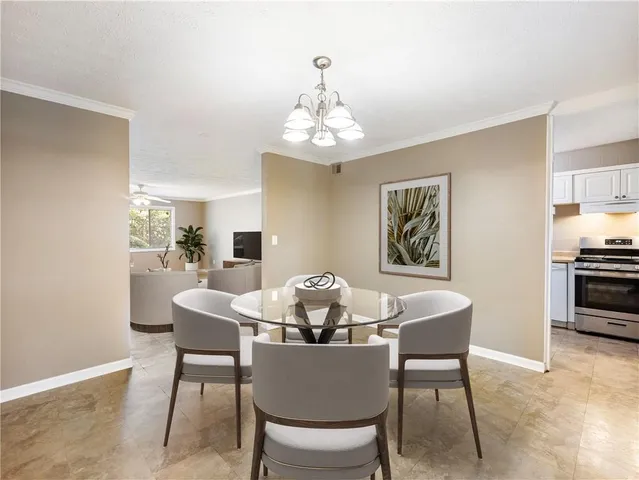 a dining room with furniture a chandelier and wooden floor