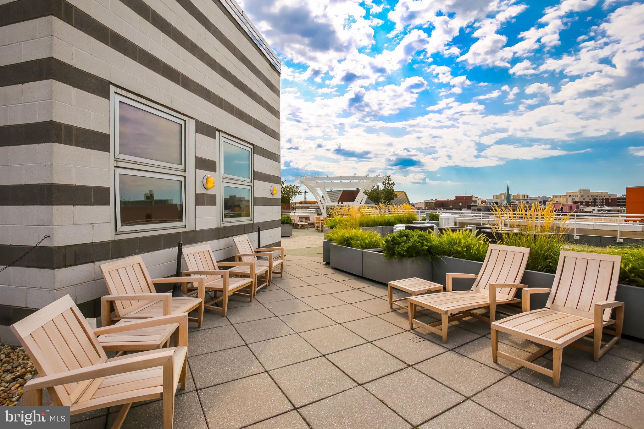 1300 13th Street Northwest, Unit 603 Washington, DC 20005 - Photo 25 of 26 a roof deck with table and chairs and potted plants