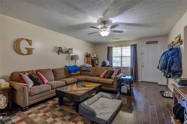 a living room with furniture a wooden floor and a chandelier