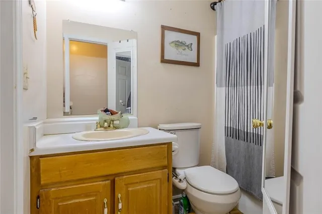 a bathroom with a granite countertop toilet sink and mirror