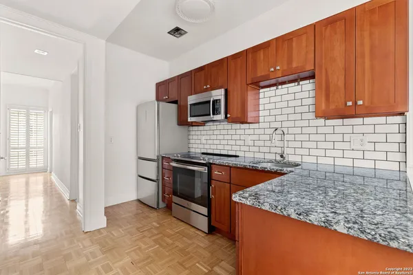 a kitchen with stainless steel appliances granite countertop a stove a sink and a microwave