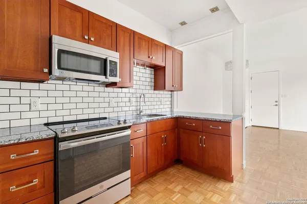 a kitchen with stainless steel appliances granite countertop a stove microwave and sink