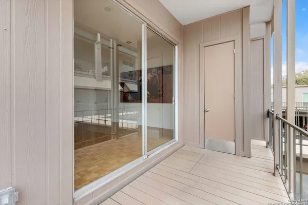 a view of a hallway with wooden floor and glass door