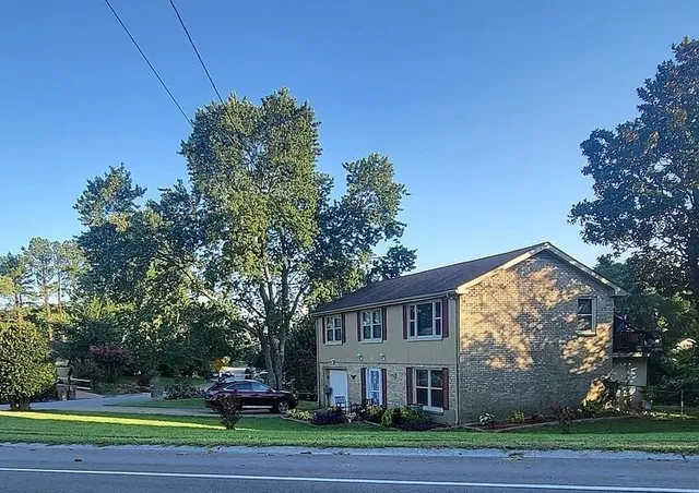 a view of a big house in a big yard with large trees