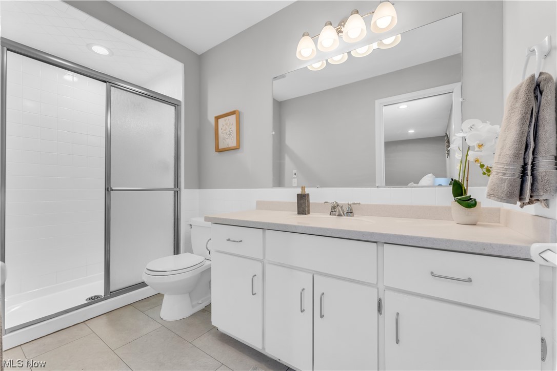 5025 Clubside Road Lyndhurst, OH 44124 - Photo 19 of 35 Bathroom featuring toilet, tile floors, vanity with extensive cabinet space, and an enclosed shower