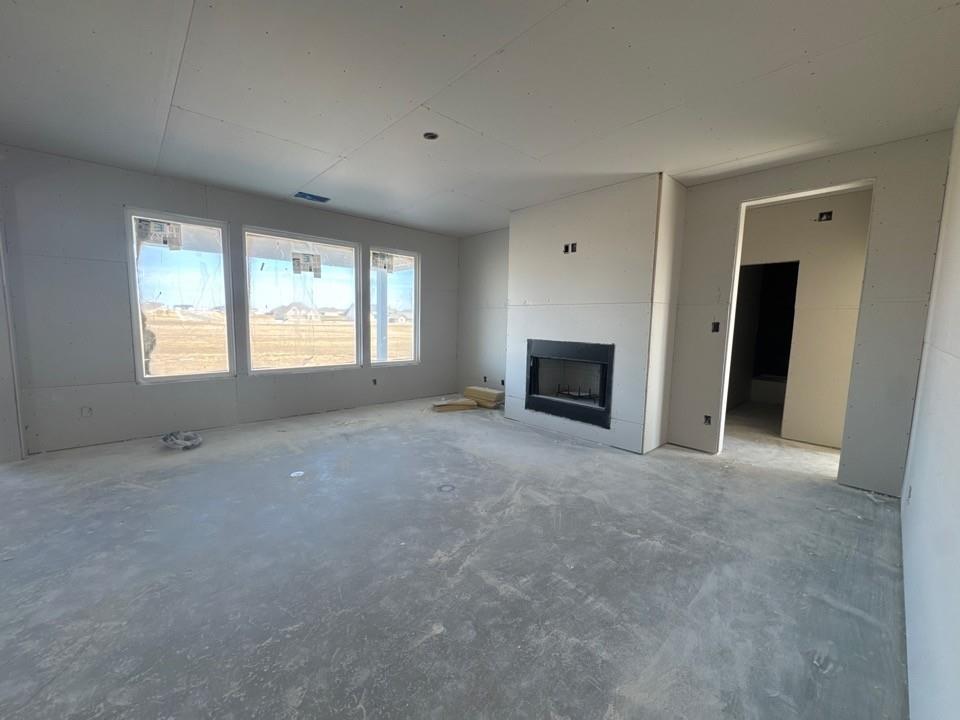 154 Snowy Owl Trail Rhome, TX 76078 - Photo 3 of 13 an empty room with a fireplace and windows