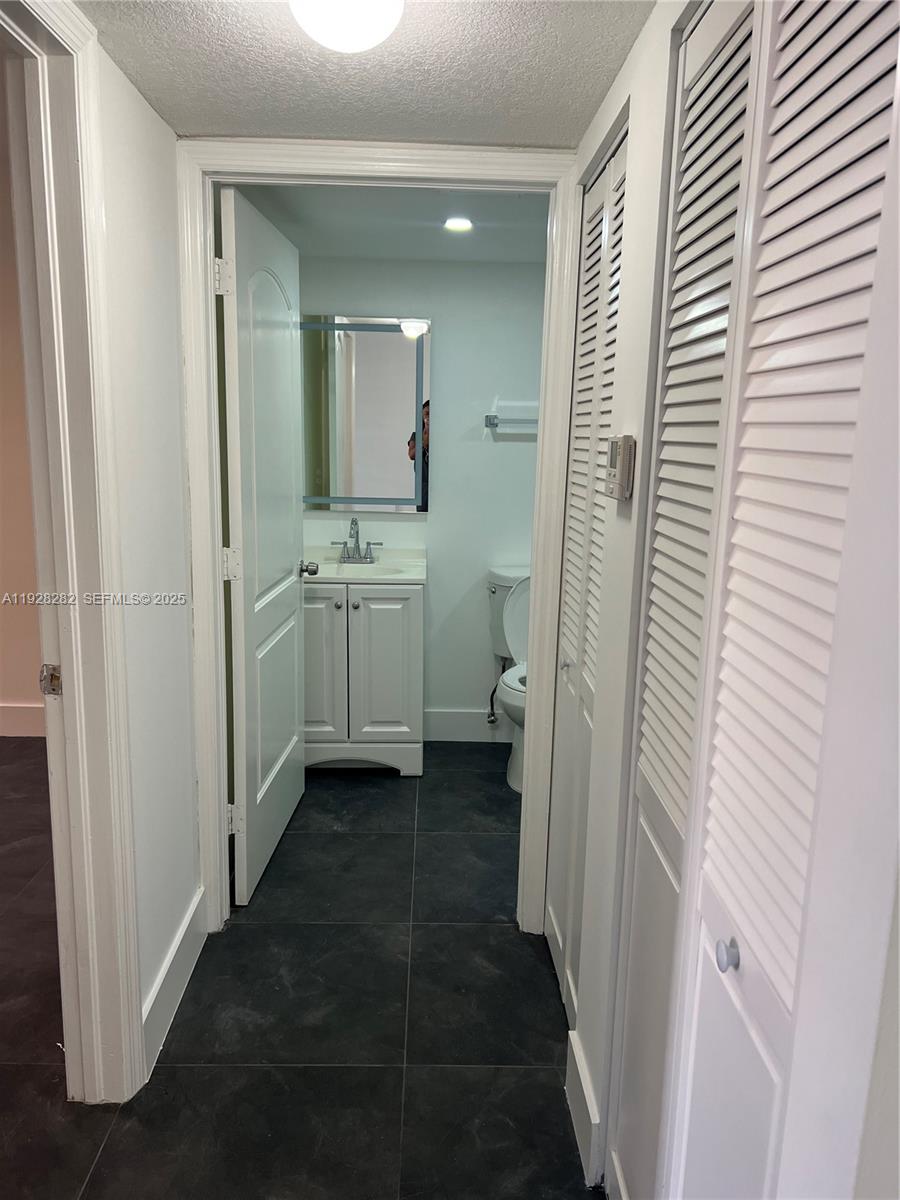 13120 Southwest 64th Terrace, Unit 1507 Miami, FL 33183 - Photo 3 of 6 a bathroom with a granite countertop sink and a mirror