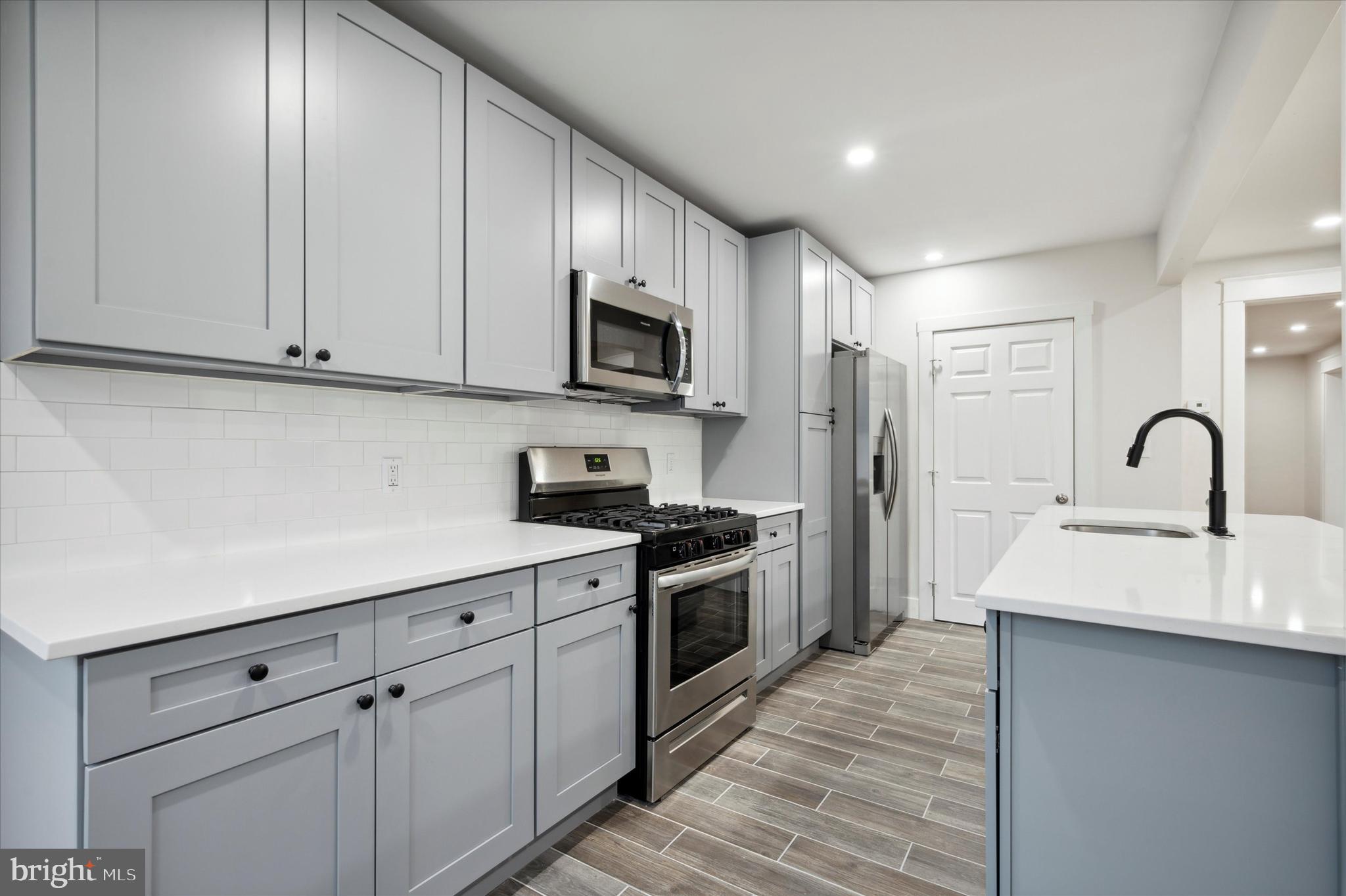 124 Walsh Road Lansdowne, PA 19050 - Photo 15 of 30 a kitchen with stainless steel appliances granite countertop a stove a sink and a refrigerator