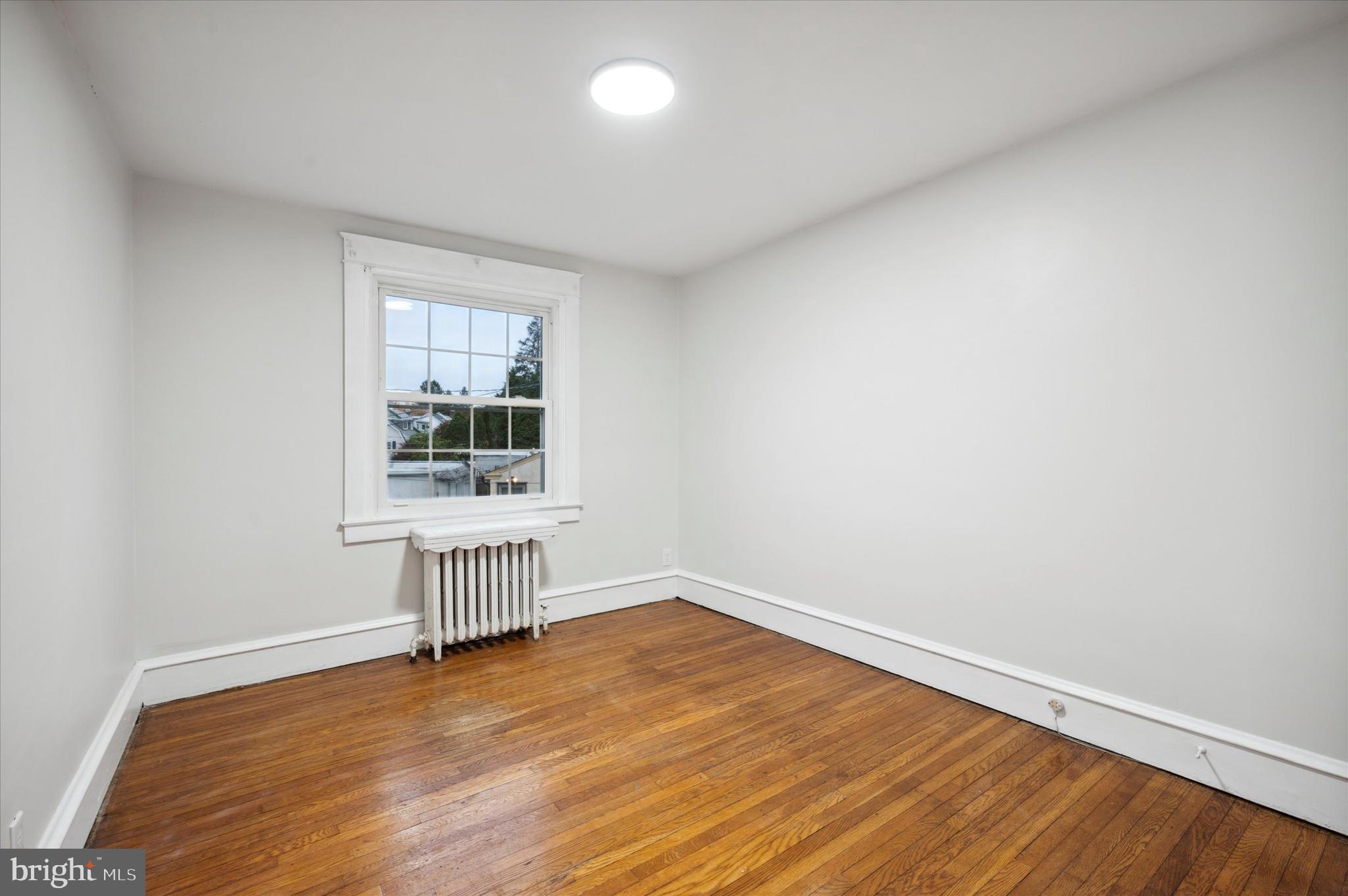 124 Walsh Road Lansdowne, PA 19050 - Photo 17 of 30 an empty room with wooden floor and windows