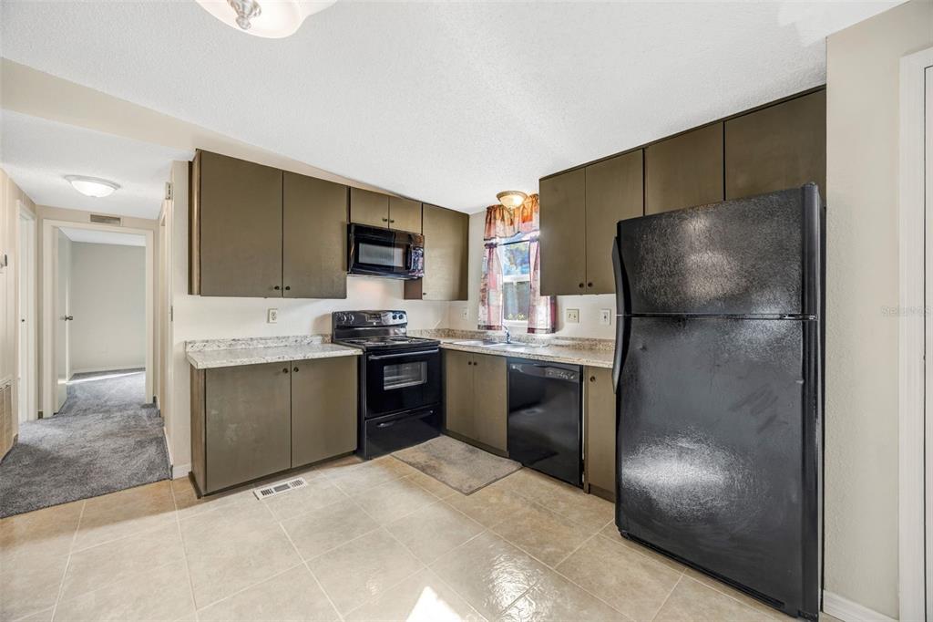 15615 Willowdale Road Tampa, FL 33625 - Photo 17 of 39 a kitchen with a refrigerator and a stove top oven