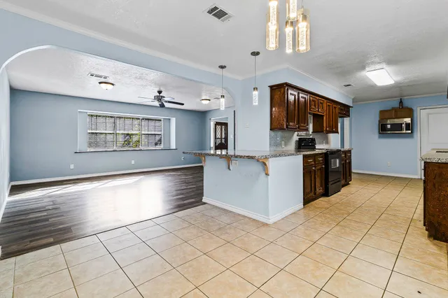 a kitchen with stainless steel appliances granite countertop a stove a sink and a refrigerator