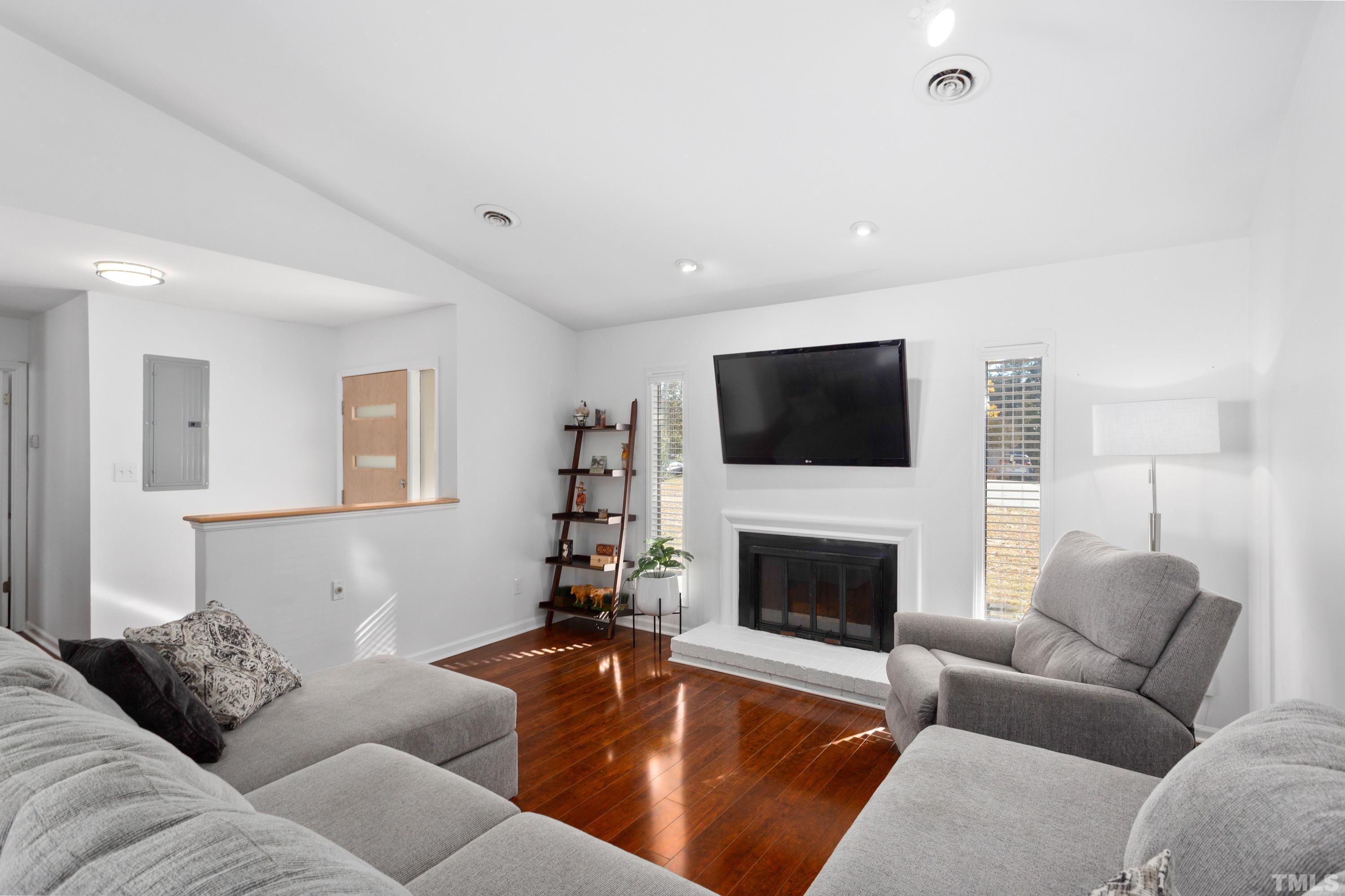 3905 Peppertree Place Raleigh, NC 27604 - Photo 3 of 25 a living room with furniture a flat screen tv and a fireplace