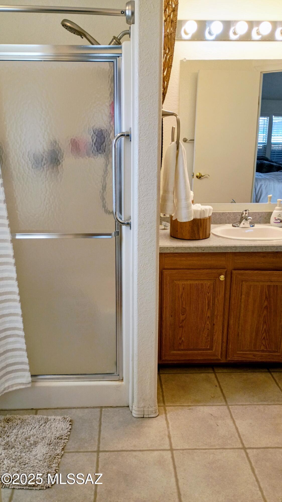 1449 West Hualpai Road Tucson, AZ 85745 - Photo 32 of 49 a bathroom with a sink a mirror and a shower