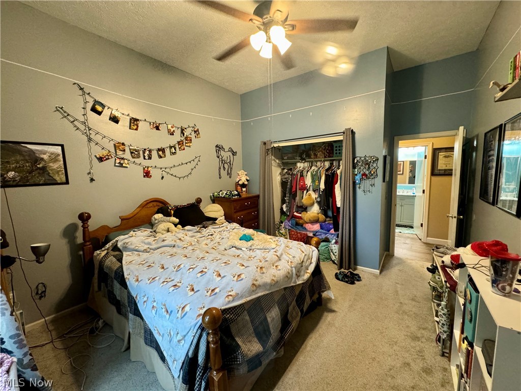 7199 Murray Ridge Road Elyria, OH 44035 - Photo 22 of 29 Carpeted bedroom featuring ceiling fan, a closet, and a textured ceiling