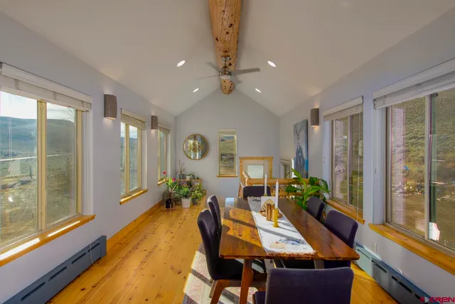 a view of a dining room with furniture large windows and wooden floor