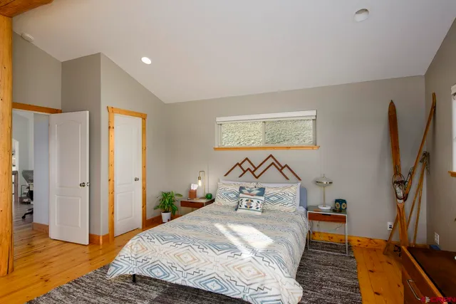 a bedroom with a bed and a flat tv screen on the dresser