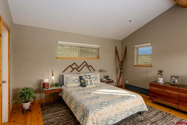 a bedroom with bed and wooden floor