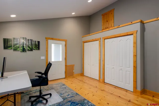 a view of a workspace with furniture and a window