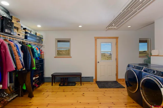 a room with lots of white furniture and a flat screen tv