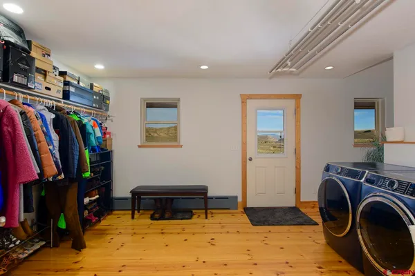 a room with lots of white furniture and a flat screen tv