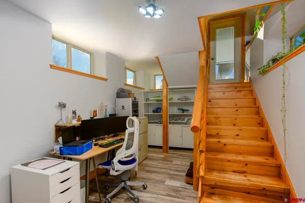 a view of a workspace with furniture and wooden floor