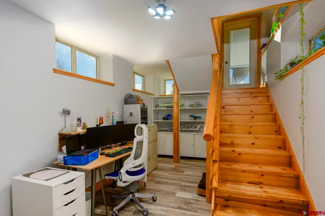 a view of a workspace with furniture and wooden floor