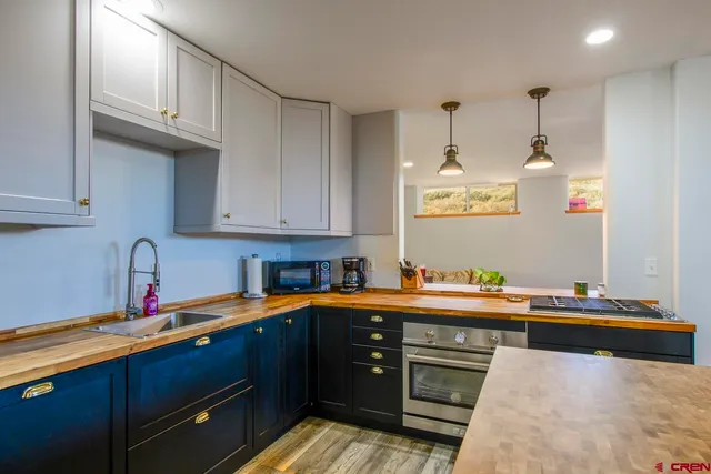 a kitchen with stainless steel appliances granite countertop a sink a stove and a microwave