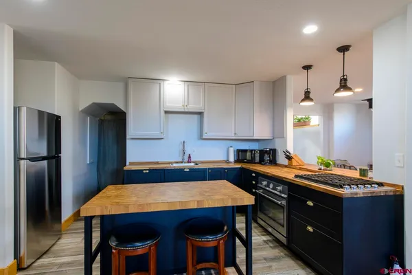 a kitchen with a table chairs refrigerator and microwave