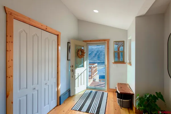 a view of a hallway with wooden floor and a livingroom with furniture