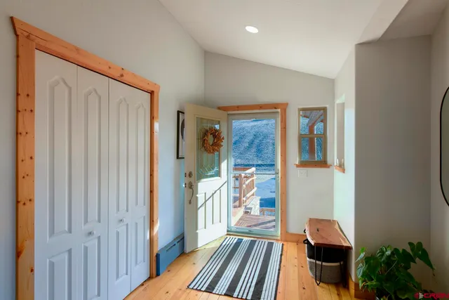 a view of a hallway with wooden floor and a livingroom with furniture