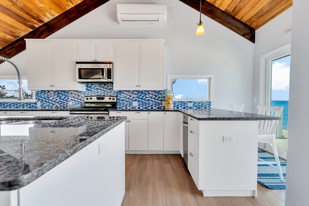 90 Salt Marsh Road East Sandwich, MA 02537 - Photo 13 of 40 a kitchen with stainless steel appliances granite countertop a sink stove and microwave