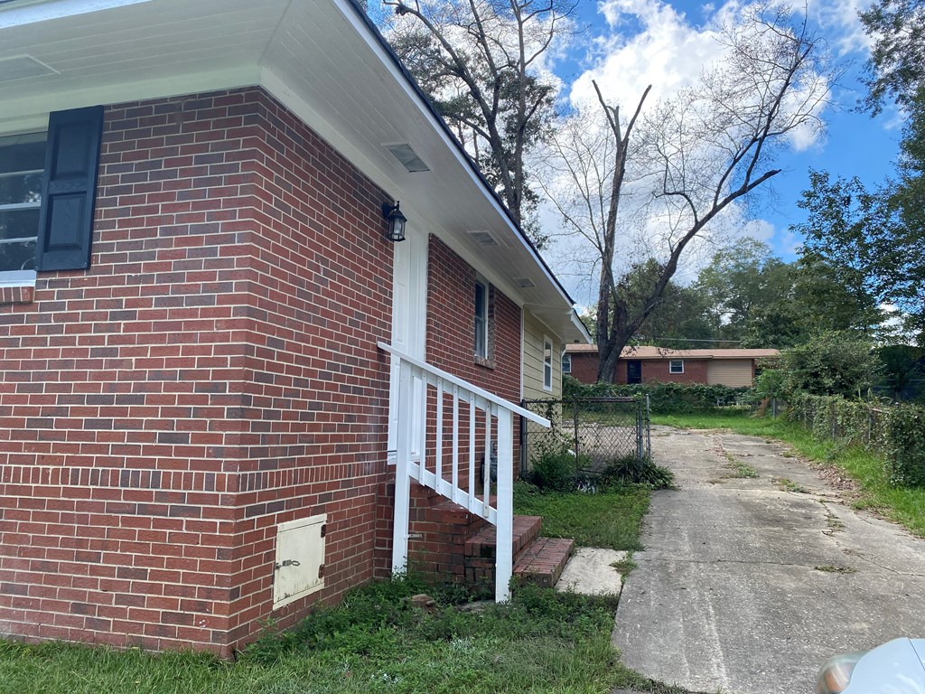 1061 Dunbar Avenue Columbus, GA 31906 - Photo 11 of 11 a view of a house with brick walls plants and large tree