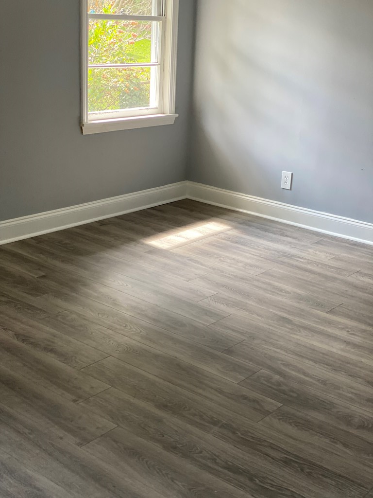 1061 Dunbar Avenue Columbus, GA 31906 - Photo 5 of 11 an empty room with wooden floor and windows