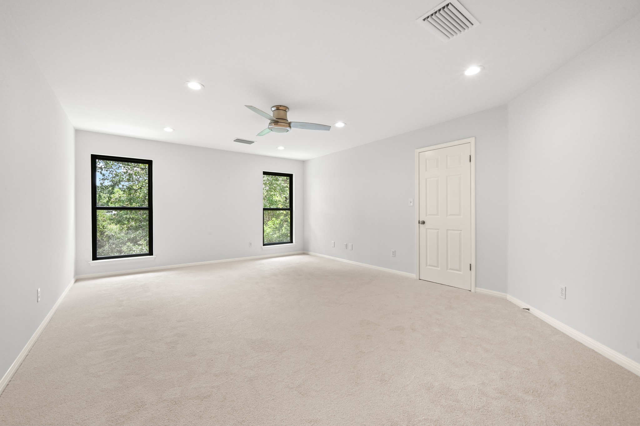 1107 Bowie Road Austin, TX 78733 - Photo 23 of 40 A spacious, naturally illuminated room features plush carpeting, recessed lighting, and a modern ceiling fan.
