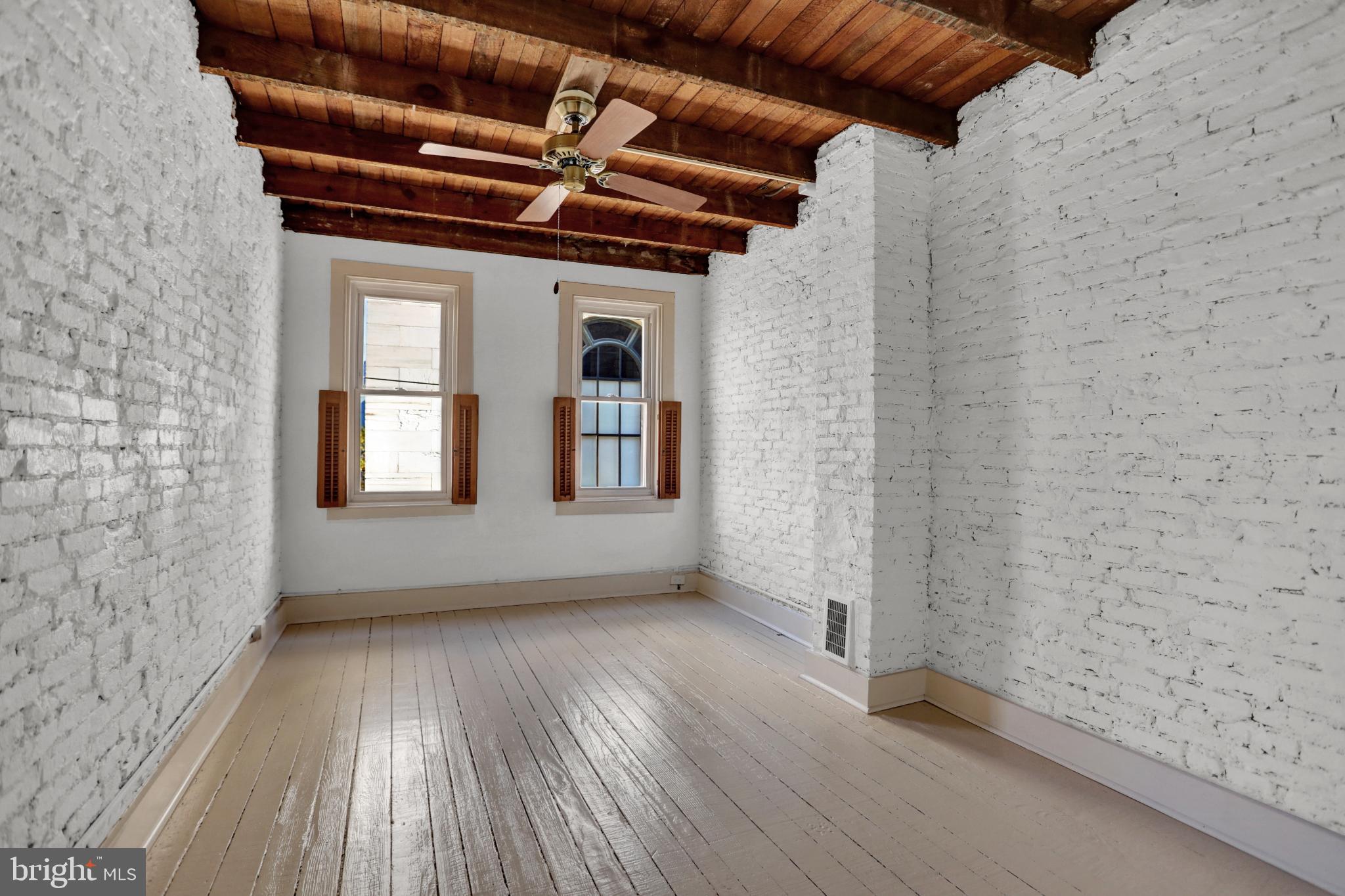 1306 Rutter Street Baltimore, MD 21217 - Photo 12 of 27 a view of an empty room with wooden floor and a window